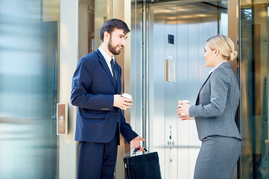 Business man and woman waiting for an elevator; elevator speech concept