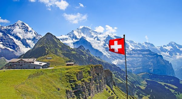 Швейцарский флаг на фоне гор